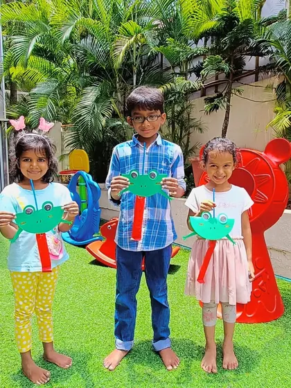 Posing in our outdoor play area with their frog crafts. We love taking our activities outside to enjoy the fresh air and sunshine.
