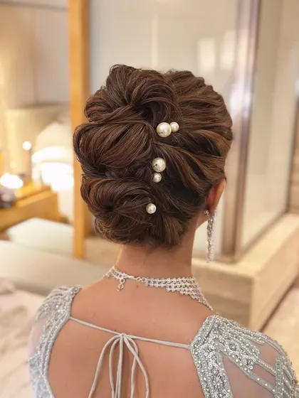This is my signature "perfectly undone" look. I created this soft, textured messy bun to feel romantic and effortless, elevated with delicate pearl pins for a touch of class. It’s a versatile bridal updo that works beautifully for both the wedding ceremony and reception.