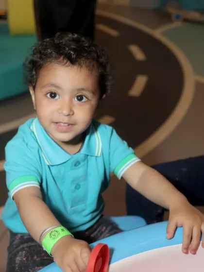 A close-up of a happy toddler engaged in sensory play at one of our activity tables.