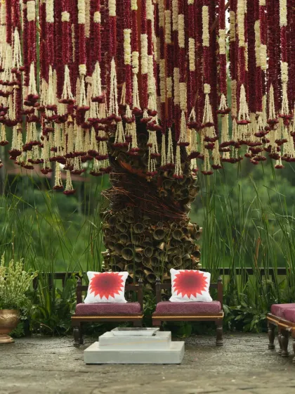 A focused view of the couple's chairs under the floral canopy, highlighting the detailed craftsmanship of the Banaras Ghat inspired decor.