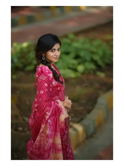 A lovely outdoor portrait in a pink saree. The soft light and her gentle expression give this image a sweet and romantic feel.