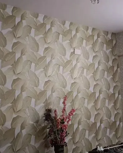 A bedroom with a large-scale leaf pattern wallpaper in neutral tones, creating a calm and organic feel.