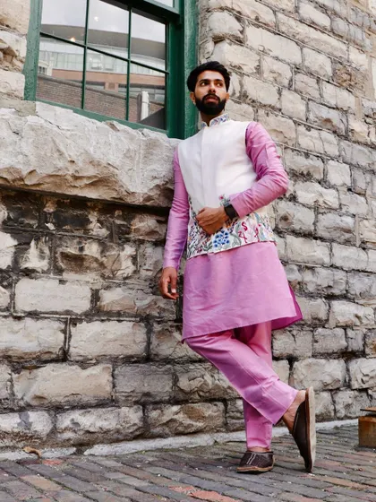 A full-length view of our white Nehru jacket with colorful floral embroidery, layered over a pink kurta. This outfit is a perfect fusion of modern colors and traditional craftsmanship.