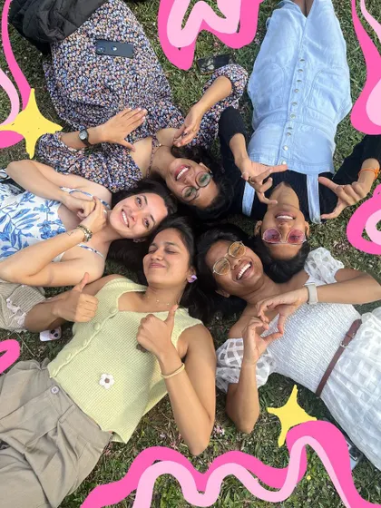 A classic "friends lying on the grass" photo, made even more fun with bright pink doodles and stars.