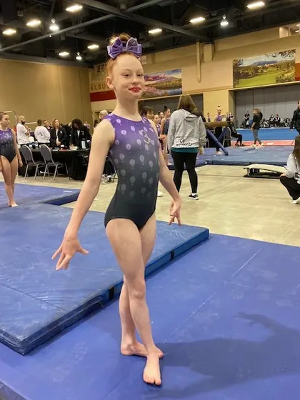 A Level 7 gymnast presents herself on the floor at Regionals in Albuquerque.