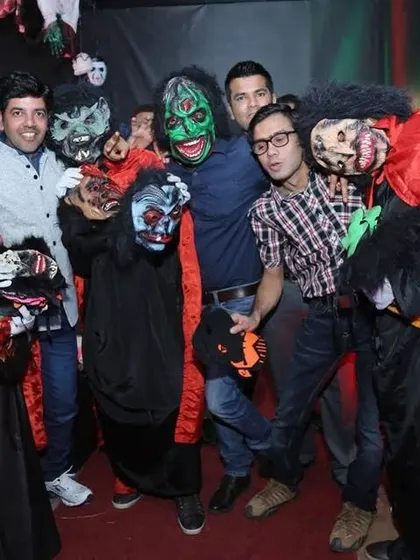 Our decor helps guests get into the spirit. Here, partygoers are using our spooky masks and enjoying the themed photo area we set up.