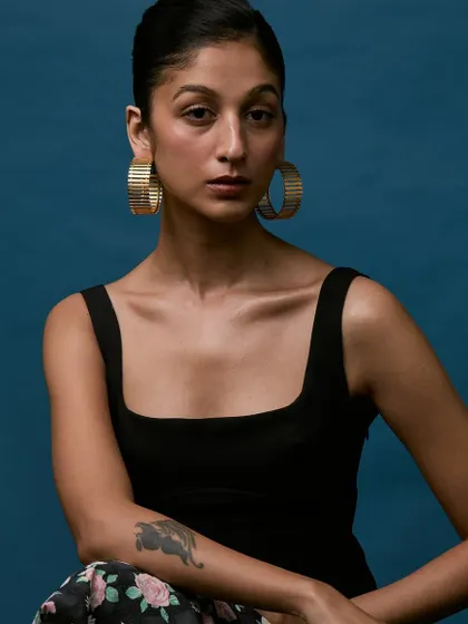 A tighter crop to emphasize the large hoop earrings and the model's expression. Clean, focused shots like this are crucial for showcasing jewelry.