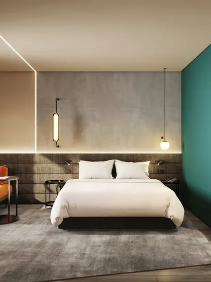 A modern hotel room with a bold color accent wall and minimalist furniture. The design is both stylish and functional, catering to the needs of a modern traveler.
