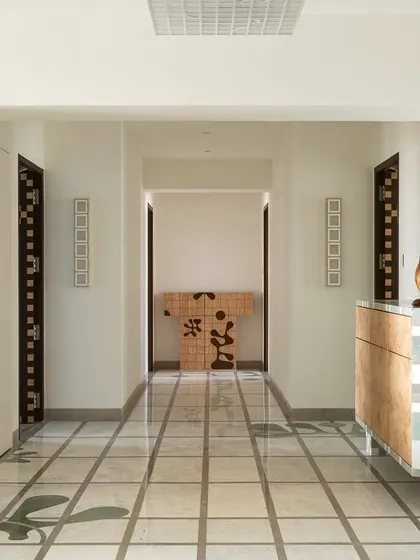 The periscopic foyer in Gingham Dreams, where a marble grid on the floor is mirrored by extruded geometric motifs on the ceiling.