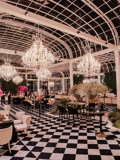In this pre-wedding event, I transformed a modern glasshouse into a chic European conservatory. The striking black and white checkered floor contrasts with vibrant pink and lilac florals, while grand chandeliers add a touch of timeless glamour, creating an atmosphere of sophisticated romance.