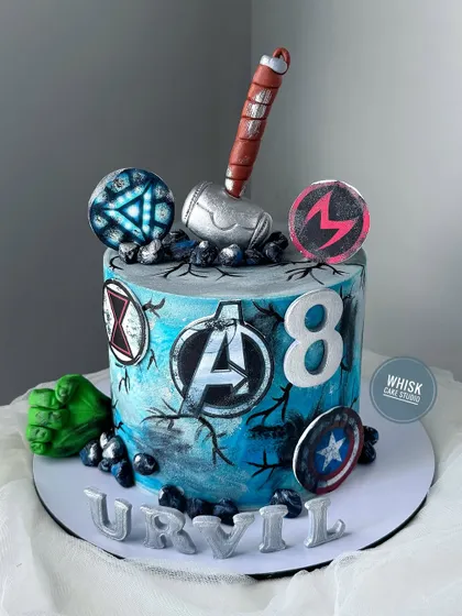 Avengers, assemble! A superhero cake for an 8th birthday, featuring iconic symbols like Thor's hammer, Captain America's shield, and the Hulk's fist.