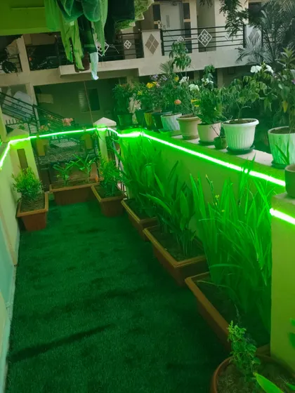 A complete balcony makeover featuring high-quality artificial grass and integrated green LED strip lighting along the ledge. This is an ideal low-maintenance solution for city apartments, providing a vibrant green space without the need for daily upkeep.