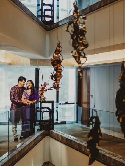 A wide shot of the couple in a modern, architecturally interesting space. This photo captures them in their environment, telling a larger story about their style and the setting of their celebration.