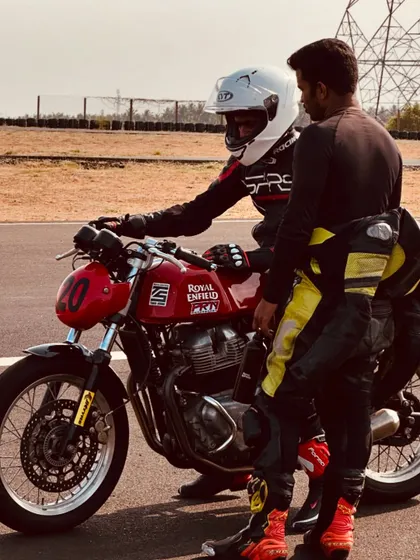 A coach gives instructions to a rider on the starting grid. This personalized guidance is crucial for building confidence and ensuring riders are prepared for every session.