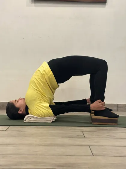 By elevating the feet on blocks in Chatushpadasana, we can achieve a deeper lift in the hips and a greater opening in the front of the body. This variation is excellent for improving spinal flexibility and posture.