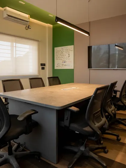 The main conference room is designed for collaboration, with a large central table, ergonomic chairs, and a feature wall with a whiteboard for brainstorming sessions.