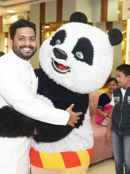 A guest shares a hug with the panda mascot, showing the fun and interactive elements of the party.