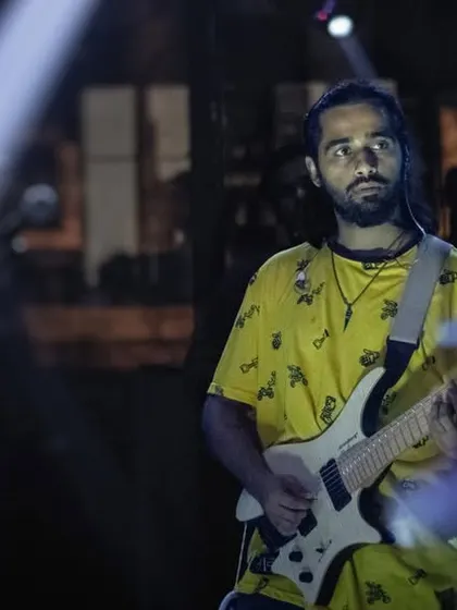 Our guitarist, caught in a beam of light, completely focused on the music. We bring this level of professional musicianship and passion to every live pub performance.