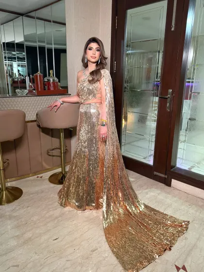 A dramatic full-length shot showing the incredible train of the Manish Malhotra sequin sari-gown. The makeup is bold enough to match this show-stopping look.