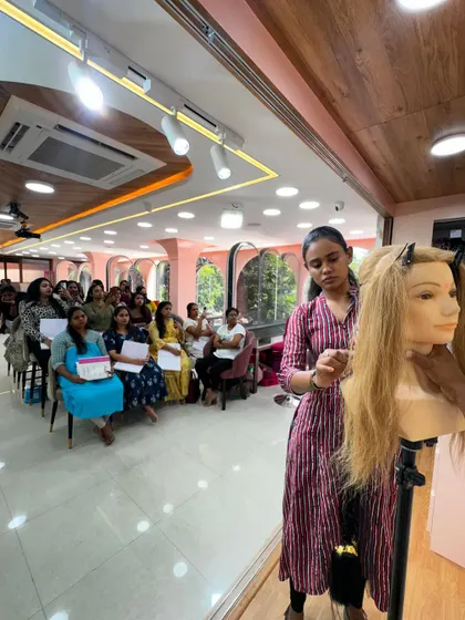 A trainer demonstrating how to create a Muhurtham hairdo on a mannequin.
