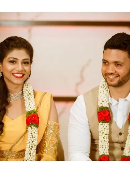 The prettiest bride, Shrusti, with her husband on their special day. She is wearing a vibrant yellow modern gown with cold-shoulder sleeves featuring delicate gold embroidery.