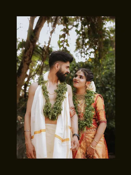 A classic portrait of a couple in their traditional wedding attire, sharing a loving gaze.