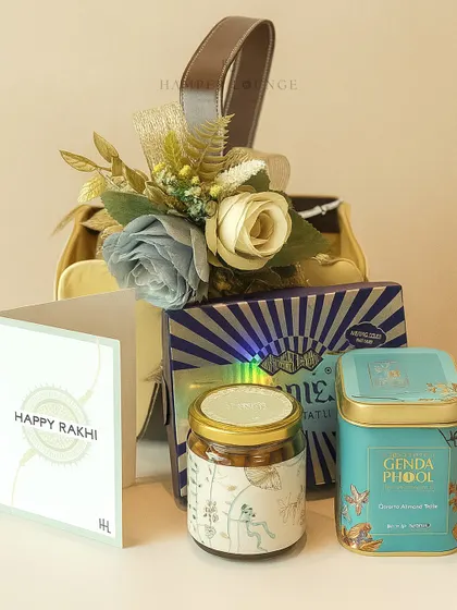 A detailed view of the miniature Rakhi hamper, showing the Genda Phool box and other gourmet items inside the stylish bag. It proves that even small gifts can be packed with luxury.