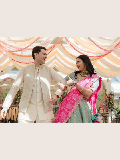 A playful dance during the Mehendi ceremony. The vibrant colors of the decor and outfits create a lively and joyful atmosphere.