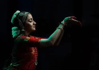 A black and white image capturing a serene moment of offering. The lighting highlights the hand gestures and the devotional expression on my face.