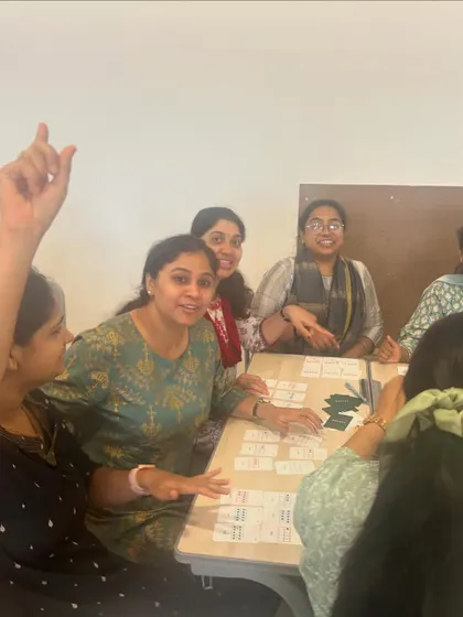 An educator raises her hand to share an idea during a lively game of Yonjuu. I use this game in teacher trainings to demonstrate how play can be a powerful tool for teaching complex math concepts.