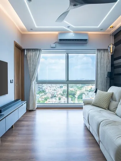 The entertainment area is designed for comfort and style, with a large screen, a sleek floating console, and a comfortable recliner sofa perfectly positioned to enjoy the city view from the large window.