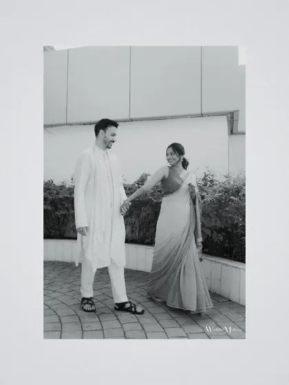 A candid black and white photo of the couple walking together, sharing a smile. This simple, happy moment is what makes wedding photography so special.