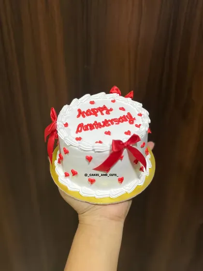 A fun anniversary bento cake with red ribbons and hearts.