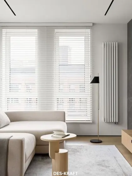 A full view of the minimalist living room, highlighting the clean lines of the furniture, the textured TV wall, and the large windows that keep the space bright.