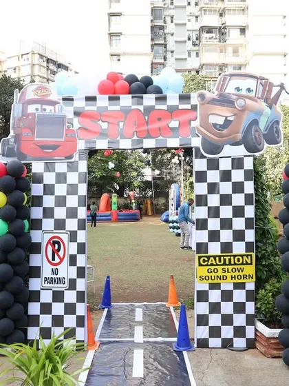 Another angle of the 'Cars' party entrance, showing the traffic light balloon columns and the road leading into the party zone.