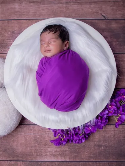 A pop of purple. A simple, overhead shot of a swaddled baby is a classic for a reason. It perfectly shows off their tiny, curled-up form.