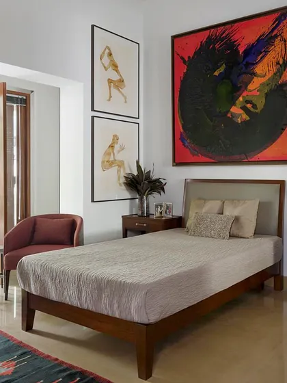 This bedroom in the Courtyard Home is defined by its bold art. A large, energetic canvas by German artist Irena Vezin is paired with delicate pen and ink drawings, creating a dynamic and artistic environment.