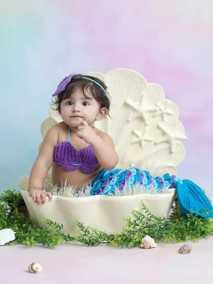 A curious glance from our little mermaid, nestled inside a giant seashell prop. These portraits are perfect for parents looking for a unique and whimsical baby photoshoot.