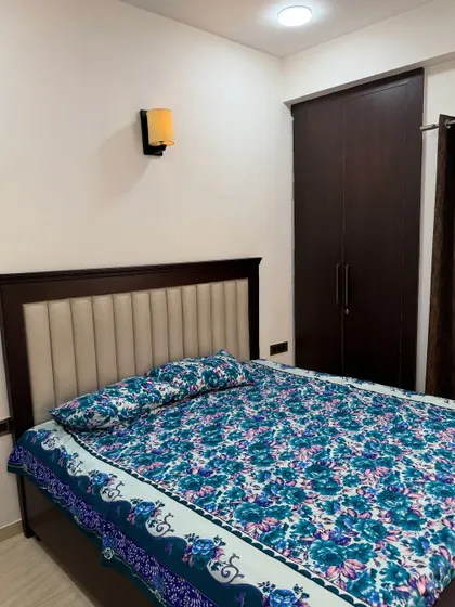 A closer look at the bed and wardrobe in this simple bedroom. The vertically upholstered headboard adds a touch of texture to the room.