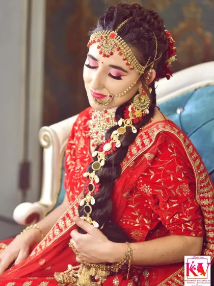 Another angle of the North Indian bridal look. Here you can see the details of the traditional braid, known as a jada, decorated with floral and gold accessories that match her red lehenga.