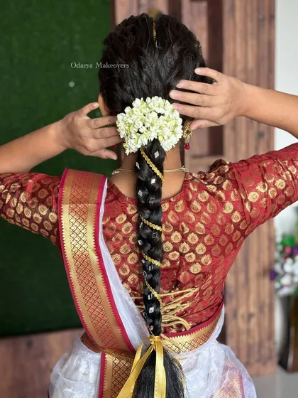A beautiful traditional hairstyle for a client dressed as Radha for her kids' school performance. The braid is adorned with fresh flowers and gold ribbon.
