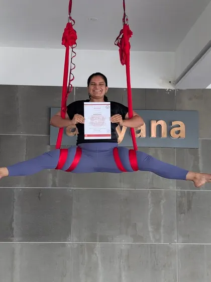 Flexibility, strength, and a huge smile. This student showcases a beautiful split in the aerial hammock, celebrating her certification.