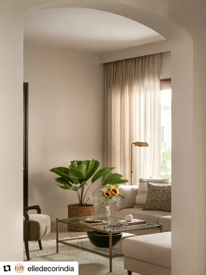 As featured in Elle Decor, this view through an archway captures the calm, light-filled atmosphere of the formal living room. The large plant and soft furnishings create a welcoming and serene space.