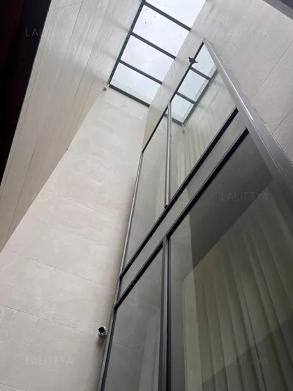 An architectural detail showing a skylight atrium that floods the interior with natural light. We often use vertical windows and skylights to create dramatic, light-filled spaces and enhance the feeling of openness within the home.
