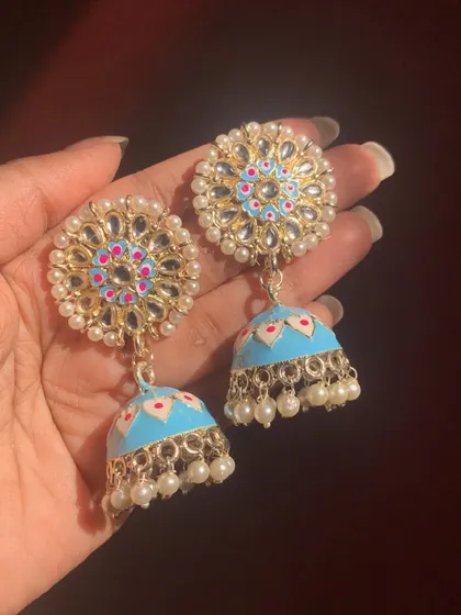 A lovely pair of light blue Meenakari jhumkas with a central kundan flower surrounded by pearls. The hand-painted details make them a work of art.
