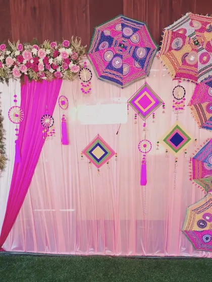 A closer look at the Mehendi backdrop, showing the colorful Rajasthani-style umbrellas and hanging tassels.
