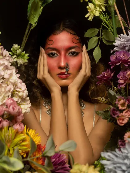 A close-up of the artistic red makeup, framed by flowers. This type of high-concept editorial work allows me to play with color, texture, and placement beyond traditional makeup.