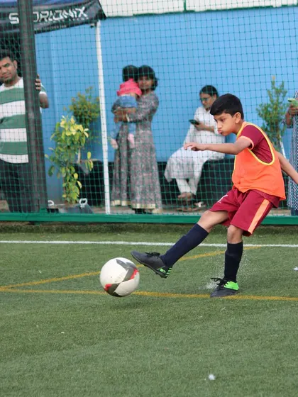 A young player focuses intently as he prepares to strike the ball during a competitive tournament match.