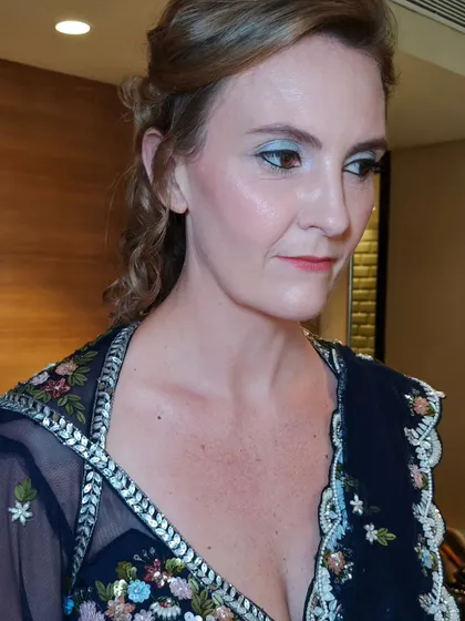 A side view of her party look. The soft curls and glowing skin create a very glamorous and polished effect.