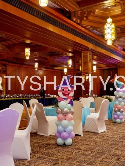 Themed centerpieces featuring Baby Shark characters on balloon columns, adding a playful touch to the guest tables.